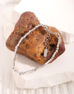 Close-up of S925 sterling silver beaded bracelet with polished cylinders on natural stone