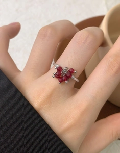 Detail of S925 sterling silver ring with small red crystal beads on woman finger
