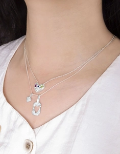 Détail d'un collier en argent S925 avec des pendentifs en cœur et des pierres précieuses
