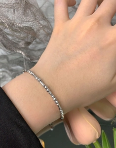 Detailed shot of S925 silver beaded bracelet with faceted beads and bamboo tubes on wrist