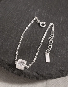 Vue macro du bracelet en argent S925 avec pendentif en zircon sur pierre noire texturée
