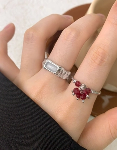 Close-up of minimalist S925 silver rings with white inlay and red crystal berry clusters