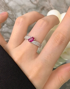 Close-up of S925 silver ring with oval ruby-red zircon and pave-set crystals