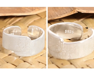 Dettaglio macro dell'anello a fascia in argento S925 con texture a puntini stampata