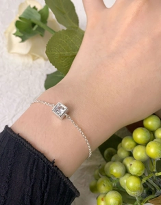 Gros plan d'une chaîne en argent S925 avec un zircon carré porté au poignet