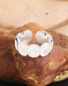 Gros plan d'une bague ovale concave en argent S925 sur des pierres naturelles