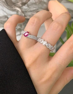 Macro shot of layered silver rings featuring oval magenta stones and micropavé diamonds