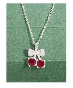 Détail du pendentif cerise en argent 925 avec zircon rouge et nœud papillon