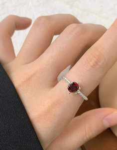 Macro view of S925 sterling silver twisted rope ring featuring a round deep red zircon