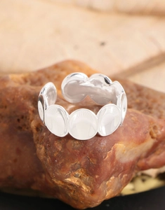 Vue macro d'une bague en argent polie sur pierre montrant une finition miroir et une taille ajustable