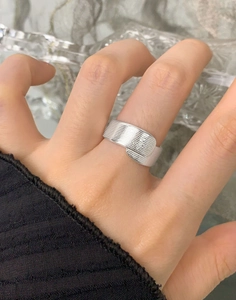 Dettaglio macro dell'anello largo in argento 925 stile fascia con finitura a puntini