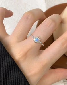 Nahaufnahme des S925 Silber Gänseblümchen-Rings mit buntem Opal an einem Finger