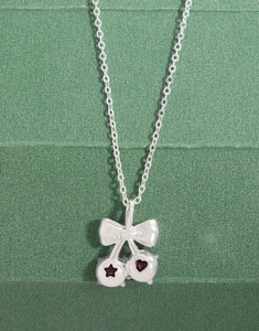 Vue macro du collier cerise en argent S925 avec corindon rouge et nœud élégant