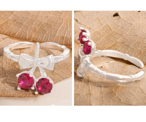 Detail of S925 sterling silver cherry bow ring with bamboo style band and red zircon stones