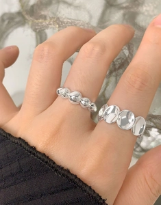 Détail d'une bague S925 ovale concave et perlée sur main de mannequin en style minimaliste