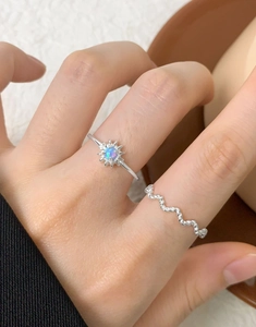Nahaufnahme von S925 Sterling Silber Gänseblümchen Opal Ring und Wellenring am Finger
