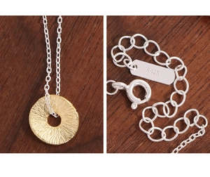 Close-up of S925 sterling silver lobster clasp and textured gold coin pendant details