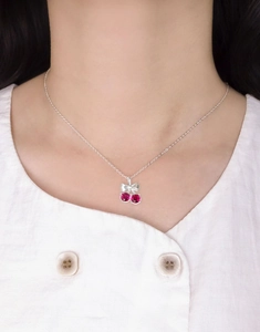 Gros plan du collier nœud cerise avec pierres de corindon rouge sur chaîne en argent