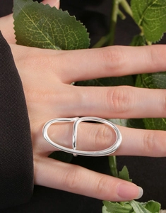 Detail of silver irregular double finger ring on model in minimalist professional style