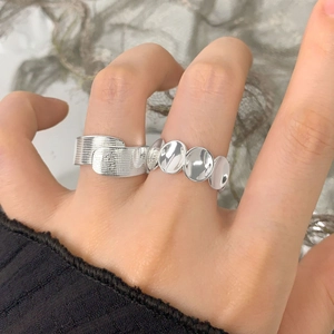 Bagues en argent à plaques ovales polies et à mailles texturées sur main de mannequin