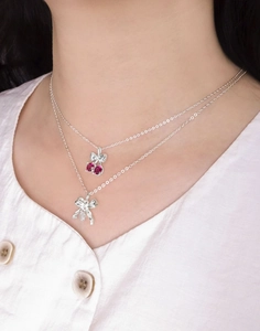 Gros plan du collier double rang en argent S925 avec nœud cerise et rubis rose