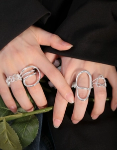 Close-up of S925 sterling silver irregular ribbon rings worn together on fingers