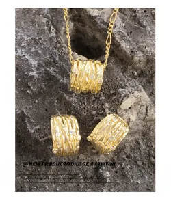 Macro shot of gold irregular coiled wire earrings and necklace set with zircon accents