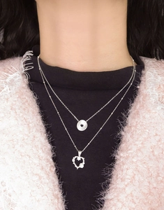 Close-up of S925 sterling silver layered necklace with round disc and heart pendants