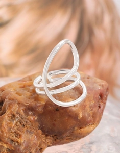 Macro view of S925 silver layered curved line ring on a textured natural stone base