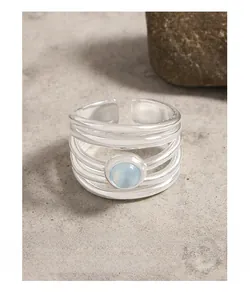 Macro detail of multi-layer S925 silver ring with a round blue aquamarine gemstone