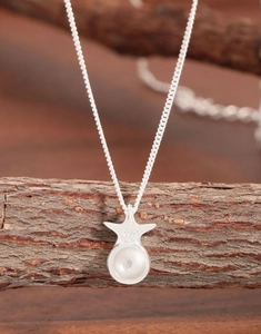 Close-up of S925 sterling silver star necklace showing hallmark stamp on natural bark background