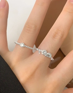 Macro detail of S925 sterling silver rings set with zircon crescent and shell charms