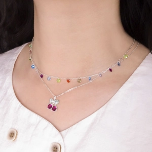 Collier cerise en argent avec nœud papillon et perles colorées porté sur le cou