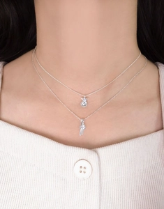 Detail of layered S925 silver necklace with star beads and knot pendant on model