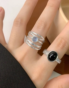 Detail of natural aquamarine silver ring with irregular line design on model hand