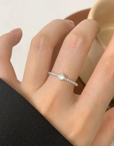 Close-up of minimalist S925 silver beaded ring featuring a clear zircon on a model finger