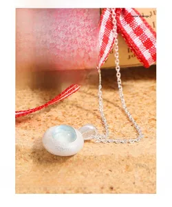 Macro view of matte S925 sterling silver necklace with round light blue aquamarine pendant