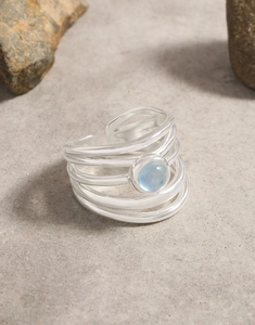 Detail of silver multi-layer open ring with round light blue aquamarine stone