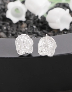 Macro shot of S925 sterling silver earrings with irregular lava texture and hallmark