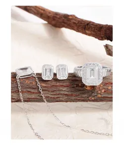 Macro shot of 925 silver jewelry set with emerald-cut crystals on rustic wood