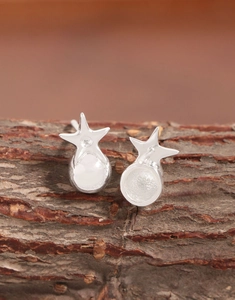 Macro des boucles d'oreilles étoile en argent 925 montrant le poinçon et le poli