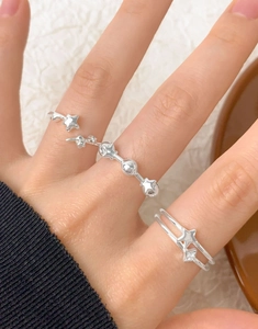 Detail of S925 sterling silver ring set featuring star charms and bead accents on hand