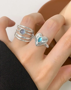 Detail of silver rings featuring layered band with lavender stone and heart shape design