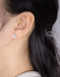 Vue détaillée de boucles d'oreilles étoile en argent avec zircon bleu sur l'oreille