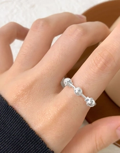 Macro shot of S925 sterling silver ring with polished bead and stars on finger