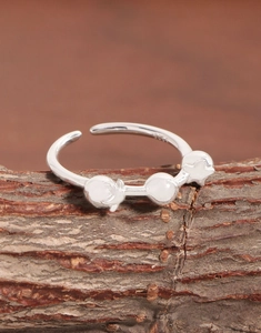 Macro shot of S925 sterling silver ring with ball and star charms on rustic wood