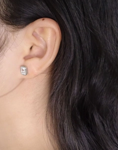 Close-up of minimalist S925 silver stud earring with emerald-cut cubic zirconia on ear