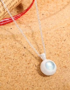 Macro shot of silver aquamarine necklace with brushed texture on cork background