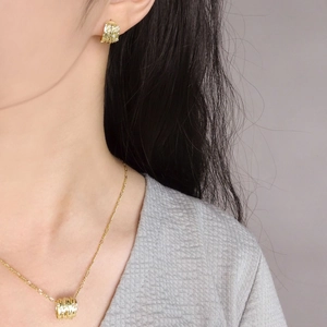 Irregular textured gold pendant necklace and matching stud earrings with zircon