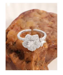 Dettaglio macro di anello a fiore in argento S925 con pavé di zirconi e farfalla